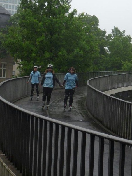 3 Schülerinnen fahren mit Inline Skates eine Brücke herunter