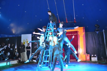 mehrere Schüler bilden ein Akrobatikbild mit Leitern