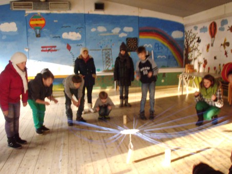 eine Gruppe von Lehrern und Schülern steht in einer Turnhalle und spielt ein Spiel