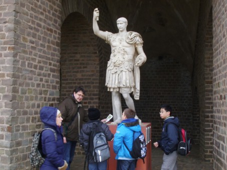 4 Schüler und 1 Lehrer stehen vor einer römischen Statue