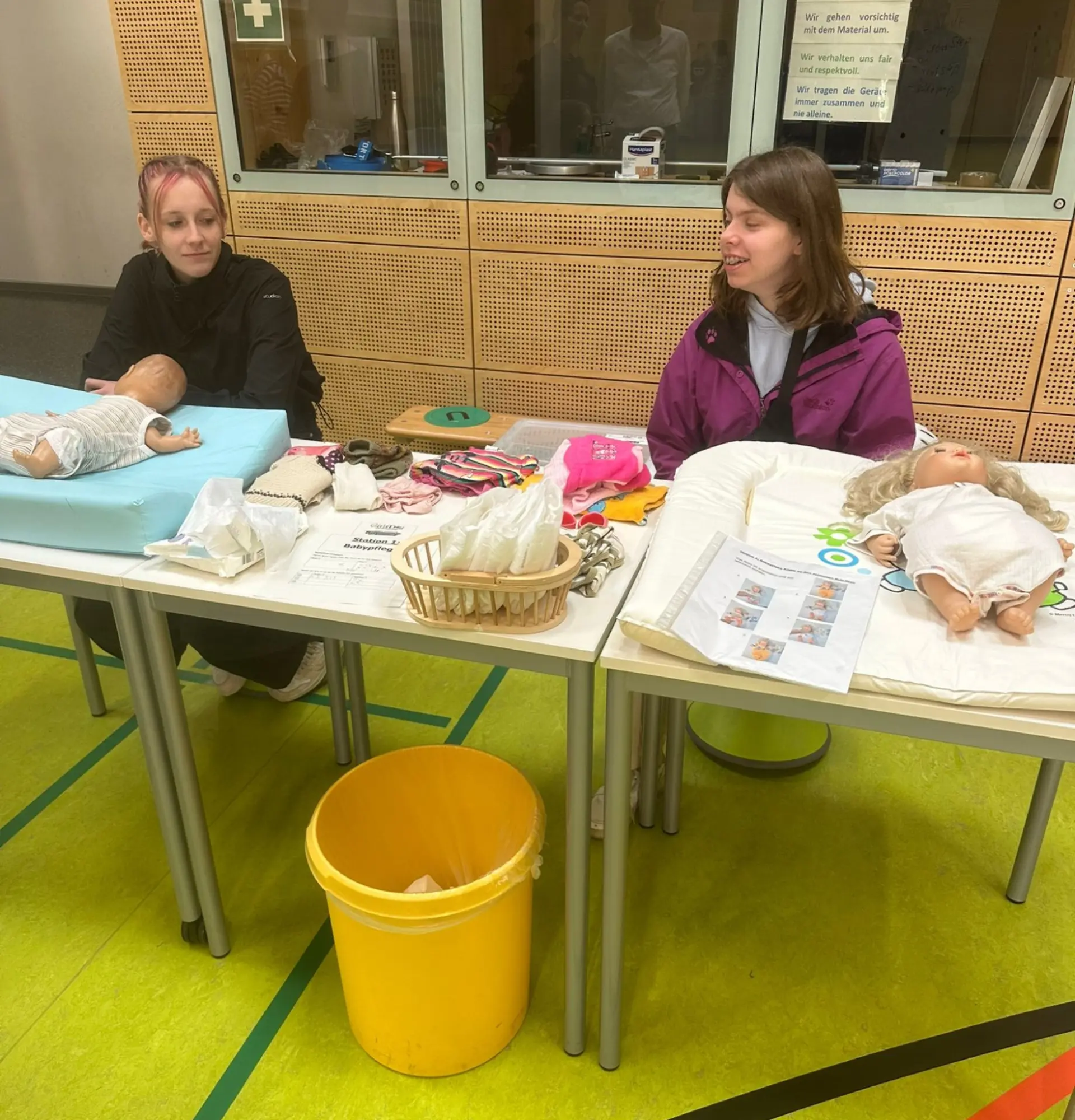 Schüler*innen üben das Wickeln von Baby an Puppen