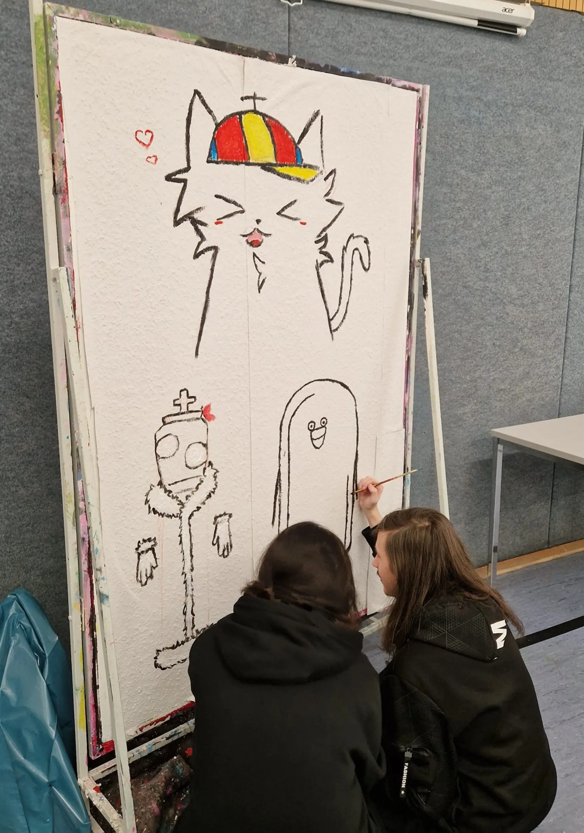 Schüler*innen zeichnen Comics an einer Tapetenwand.